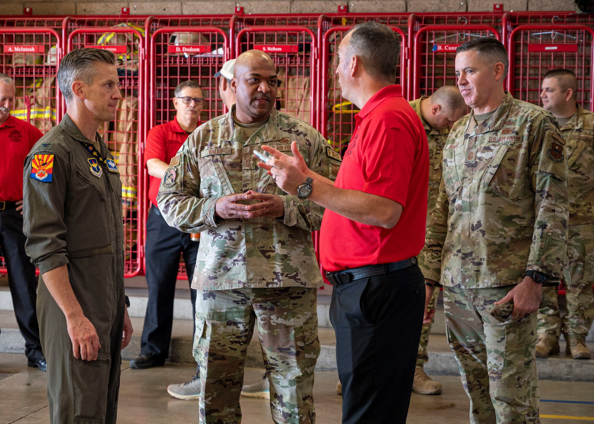 U.S. Air Force Col. Keagan McLeese, 56th Fighter Wing vice wing commander (far left), CMSgt. Darnell Walls, 56th Civil Engineer Squadron fire chief (center left), and CMSgt. Jason Shaffer, 56th FW command chief (far right), listen to Jason Haddock, 56th CES assistant fire chief (center right), at the start of Fire Prevention Week Oct. 7, 2022, at Luke Air Force Base, Arizona.