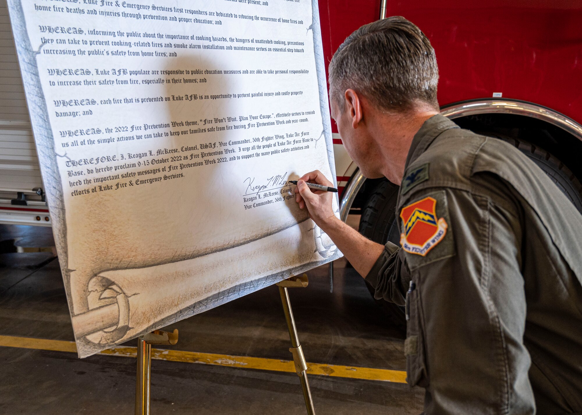 U.S. Air Force Col. Keagan McLeese, 56th Fighter Wing vice commander, signs the 100th Anniversary Fire Prevention Week Proclamation Oct. 7, 2022, at Luke Air Force Base, Arizona.
