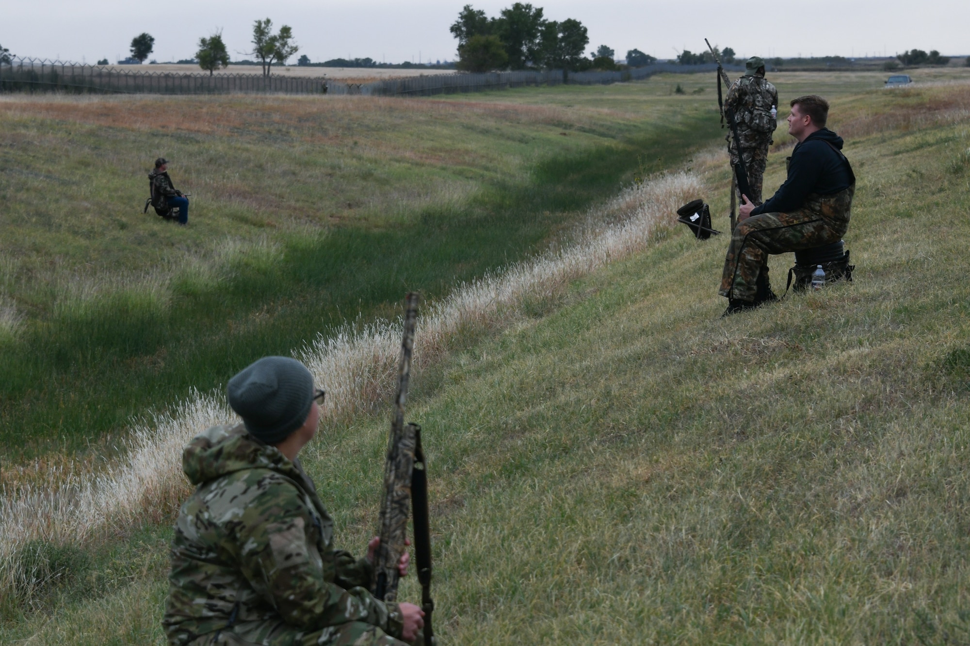 Airmen and families from the 97th Air Mobility Wing wait during a dove hunt at Altus Air Force Base, Oklahoma, Oct. 8, 2022. The dove hunt provides an opportunity for members of the community to gather and help prevent overpopulation of local fowl. (U.S. Air Force photo by Airman 1st Class Miyah Gray)