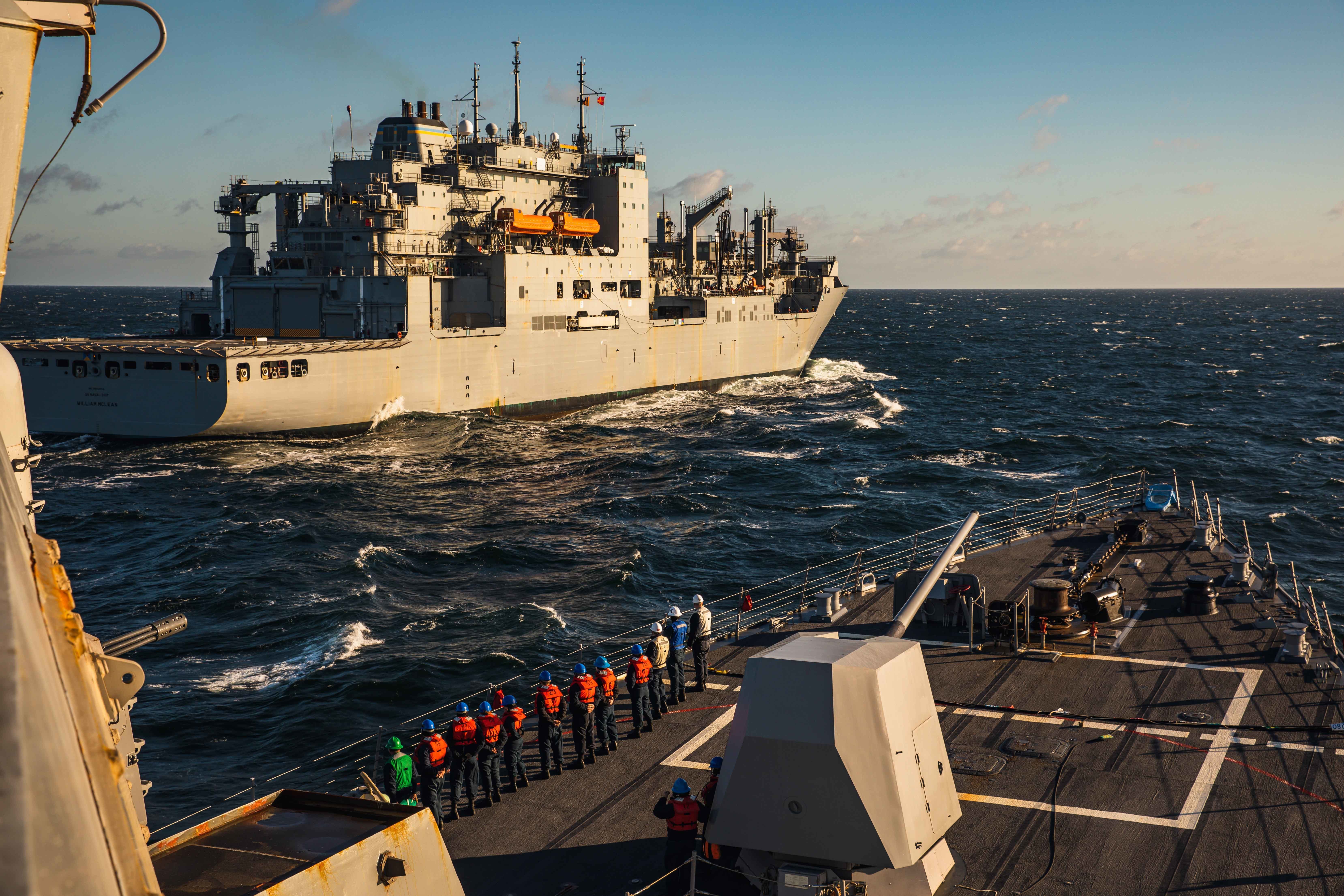 Sailors assigned to USS Paul Ignatius (DDG 117) man the rails during a replenishment-at-sea with USNS William McLean (T-AKE 12), Oct. 7, 2022.