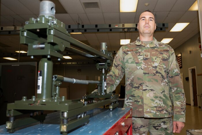 Airman standing next to piece of equipment