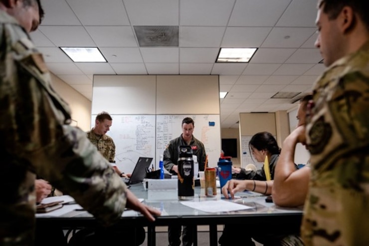 Airmen assigned to the 6th Airlift Squadron discuss a flight plan during the Tactics Advancement Course on Joint Base McGuire-Dix-Lakehurst, N.J., Sept. 26, 2022