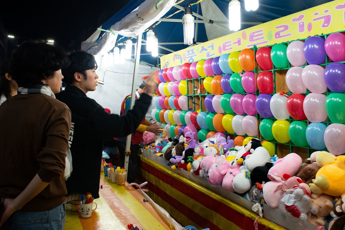 Attendees play a balloon dart game during the 19th Republic of Korea and the United States Cultural Festival, in front of Osan Air Base, Republic of Korea, Oct. 8, 2022.