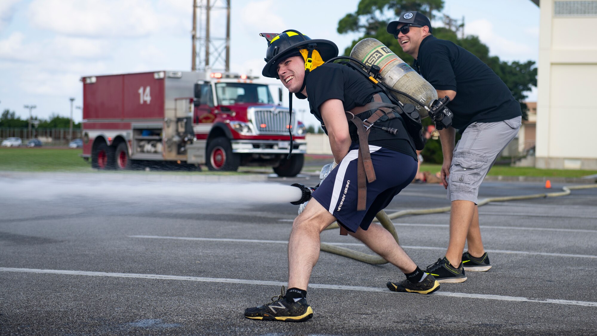 Tech Sgt. Christopher Wright, 718th Aircraft Maintenance Squadron section chief, sprays a fire hose at the fire muster challenge during National Fire Prevention Week at Kadena Air Base, Japan, Oct. 6, 2022. The competitive event was part of a week-long effort to promote fire safety and prevention to the Team Kadena community. (U.S. Air Force photo by Senior Airman Jessi Roth)