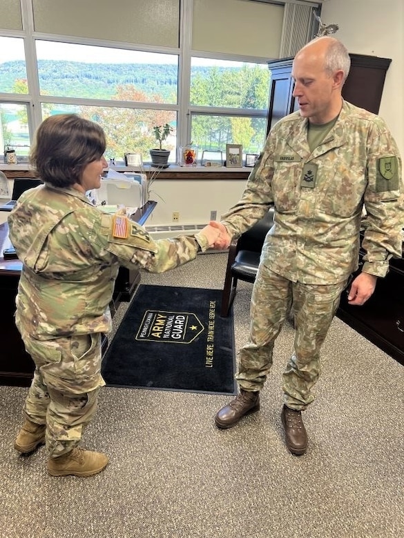 Brig. Gen. Laura McHugh, left, deputy adjutant general-Army, Pennsylvania National Guard, presents a coin to Brig. Gen. Arturas Radvilas, right, Lithuanian Land Forces commander, at the Pennsylvania National Guard Joint Force Headquarters at Fort Indiantown Gap, Pa., on Oct. 9, 2022. Radvilas, along with Brig. Gen. Modestas Petrauskas, Lithuanian defense attaché to the United States and Canada, and Command Sgt. Maj. Darius Masiulis, Lithuanian Land Forces command sergeant major, visited Fort Indiantown Gap and attended the 28th Infantry Division departure ceremony in Harrisburg on Oct. 9.