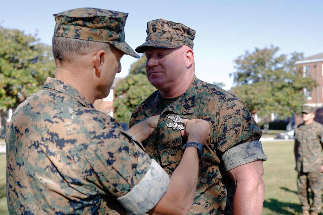 U.S. Navy Command Master Chief Scottie Cox, command master chief of 2d Marine Division (2dMARDIV), receives the Fleet Marine Force device from Maj. Gen. Francis Donovan, former commanding general of 2d MARDIV, on Camp Lejeune, North Carolina, Oct. 7, 2022. The FMF pin signifies U.S. Naval officers and sailors who are trained and qualified to perform duties in support of the U.S. Marine Corps. (U.S. Marine Corps photo by Staff Sgt. Rodion Zabolotniy)
