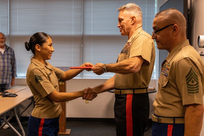 U.S. Marine Corps Sgt. Ayline Mota, Marine Corps Recruiting Commanding Supply Chief, receives award from Maj. Gen. William J. Bowers, MCRC Commanding General, and Sgt. Maj. Adan F. Moreno, MCRC Sergeant Major, at James Wesley Marsh center, on Marine Corps Base Quantico, Va., September 30. Marines and civilians receive awards for their contribution and dedication to MCRC after making mission for fiscal year 2022.