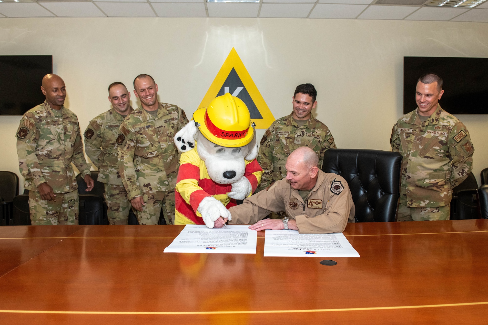 Members of the U.S. Air Force 379th Expeditionary Civil Engineer Squadron watch as Col. Dennis Cummings, 379th Air Expeditionary Wing deputy commander, signs a fire proclamation on Al Udeid Air Base, Qatar, Sept. 30, 2022. The signing of the proclamation marked the beginning of Fire Prevention Week. (U.S. Air National Guard photo by Airman 1st Class Constantine Bambakidis)