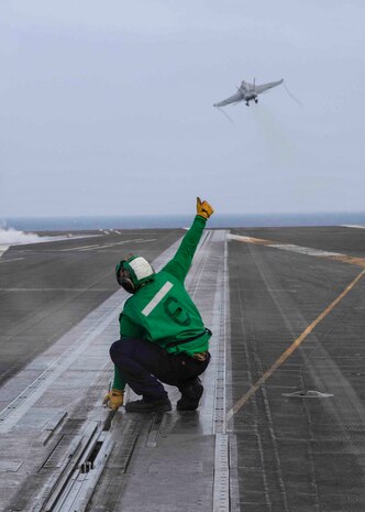 A Sailor signals as an F/A-18E Super Hornet aircraft, attached to Strike Fighter Squadron (VFA) 136, launches off the Nimitz-class aircraft carrier USS George H.W. Bush (CVN 77), Sep. 9, 2022. Carrier Air Wing (CVW) 7 is the offensive air and strike component of Carrier Strike Group (CSG) 10 and the George H.W. Bush Carrier Strike Group (GHWBCSG). The squadrons of CVW-7 are,  VFA-86, VFA-103, VFA-136, VFA-143 Electronic Attack Squadron (VAQ) 140, Carrier Airborne Early Warning Squadron (VAW) 121, Helicopter Sea Combat Squadron (HSC) 5 and Helicopter Maritime Strike Squadron (HSM) 46. The GHWBCSG is on a scheduled deployment in the U.S. Naval Forces Europe area of operations, employed by U.S. Sixth Fleet to defend U.S., allied, and partner interests.