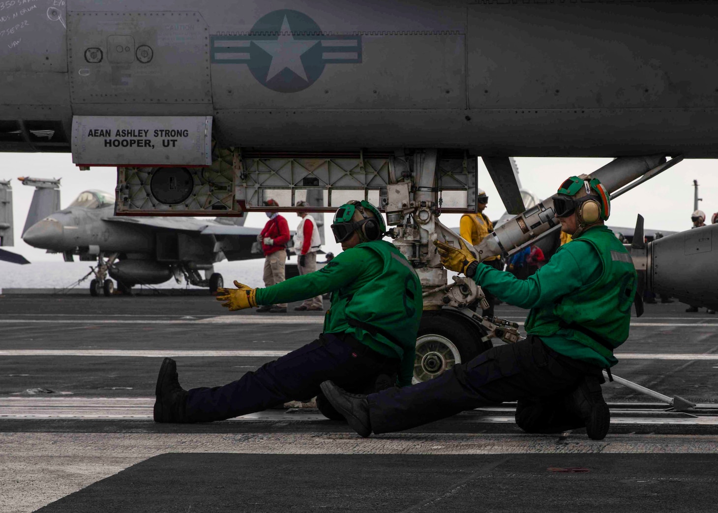 Sailors signal an F/A-18E Super Hornet aircraft, attached to Strike Fighter Squadron (VFA) 136, aboard the Nimitz-class aircraft carrier USS George H.W. Bush (CVN 77), Sep. 9, 2022. Carrier Air Wing (CVW) 7 is the offensive air and strike component of Carrier Strike Group (CSG) 10 and the George H.W. Bush Carrier Strike Group (GHWBCSG). The squadrons of CVW-7 are,  VFA-86, VFA-103, VFA-136, VFA-143 Electronic Attack Squadron (VAQ) 140, Carrier Airborne Early Warning Squadron (VAW) 121, Helicopter Sea Combat Squadron (HSC) 5 and Helicopter Maritime Strike Squadron (HSM) 46. The GHWBCSG is on a scheduled deployment in the U.S. Naval Forces Europe area of operations, employed by U.S. Sixth Fleet to defend U.S., allied, and partner interests.