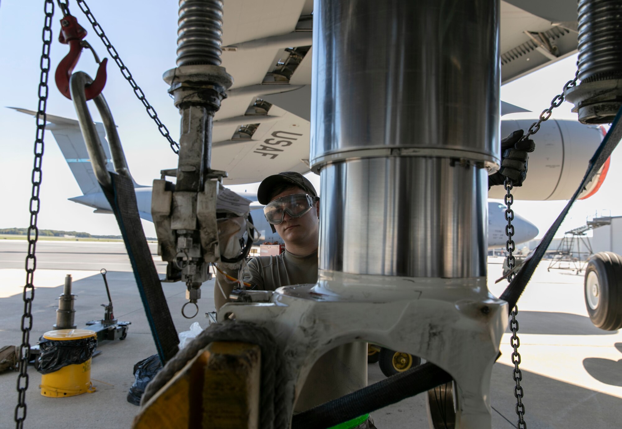 Senior Airman Andrew Small, 436th Aircraft Maintenance Squadron hydraulic systems journeyman, lowers the number three main landing gear strut assembly to perform maintenance on a C-5M Super Galaxy at Dover Air Force Base, Delaware, Oct. 6, 2022. Small and other hydraulic system maintainers replaced internal seals on the strut during the repack procedure. (U.S. Air Force photo by Roland Balik)