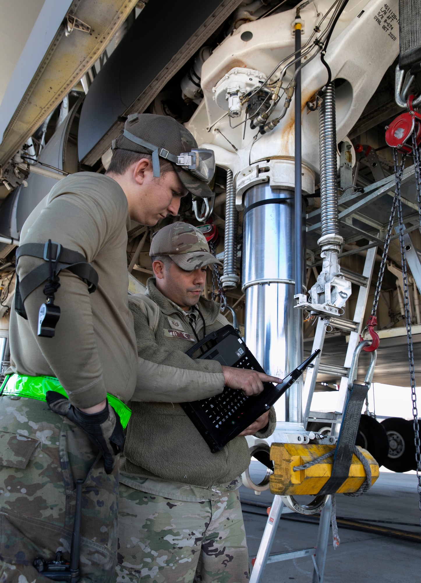 Senior Airman Andrew Small, left, 436th Aircraft Maintenance Squadron hydraulic systems journeyman, and Tech. Sgt. Victor Torres, 436th AMXS hydraulic systems craftsman, review technical orders during a C-5M Super Galaxy main landing gear strut repack at Dover Air Force Base, Delaware, Oct. 6, 2022. Small, Torres and other hydraulic system maintainers removed and replaced internal seals during the repack procedure. (U.S. Air Force photo by Roland Balik)