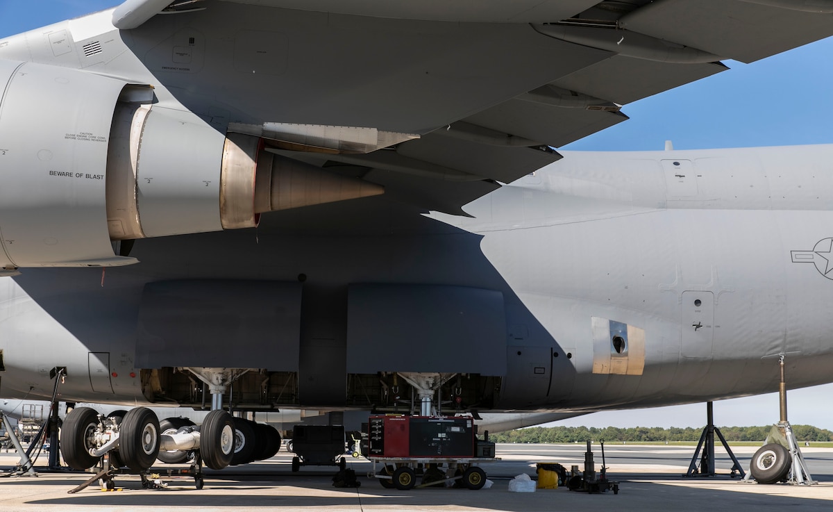 A C-5M Super Galaxy sits on jacks during a number three main landing gear strut repack at Dover Air Force Base, Delaware, Oct. 6, 2022. Hydraulic system maintainers assigned to the 436th Aircraft Maintenance Squadron removed and replaced internal seals as part of the repack procedure. (U.S. Air Force photo by Roland Balik)