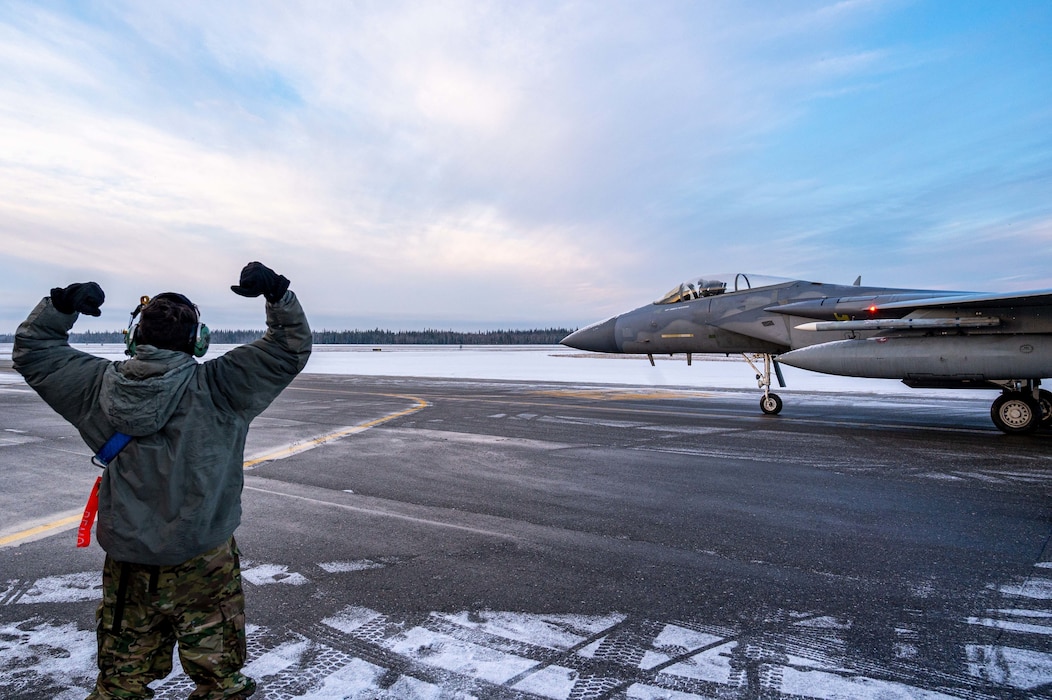 U.S. Air Force Airman 1st Class Kyle Netanel, 44th Aircraft Maintenance Unit crew chief, sends off an F-15C/D Eagle during RED FLAG-Alaska (RF-A) 23-1 at Eielson Air Force Base, Alaska, Oct. 12, 2022.