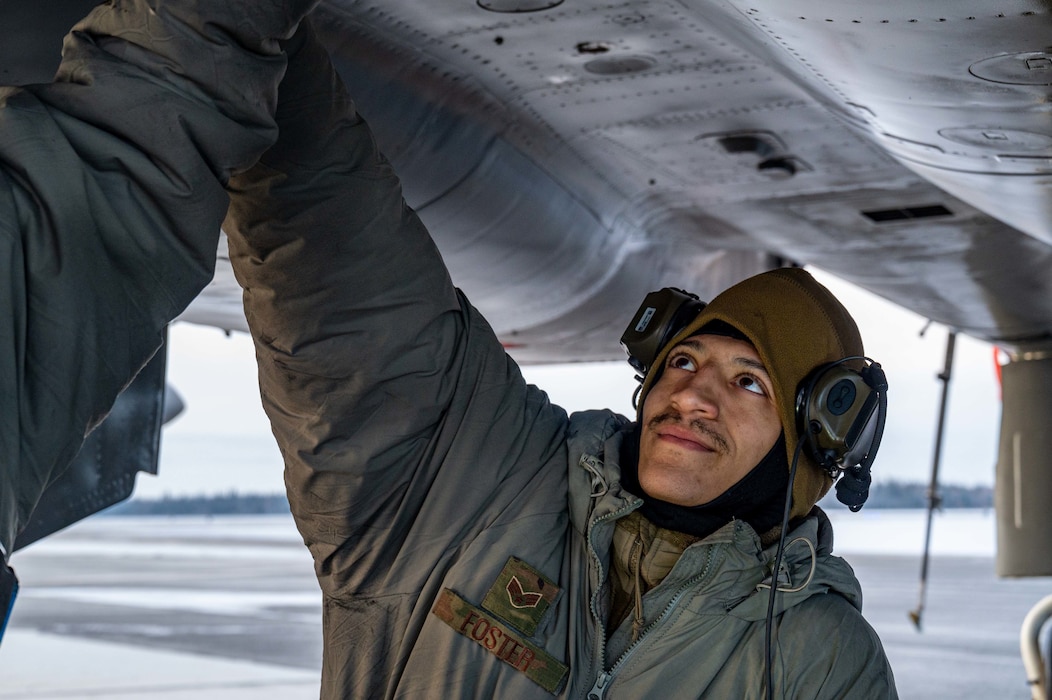 U.S Air Force Senior Airman Adrian Foster, 44th Aircraft Maintenance Unit crew chief, instructs an Airman about standard maintenance on an F-15C/D Eagle system at Eielson Air Force Base, Alaska, Oct. 12, 2022.