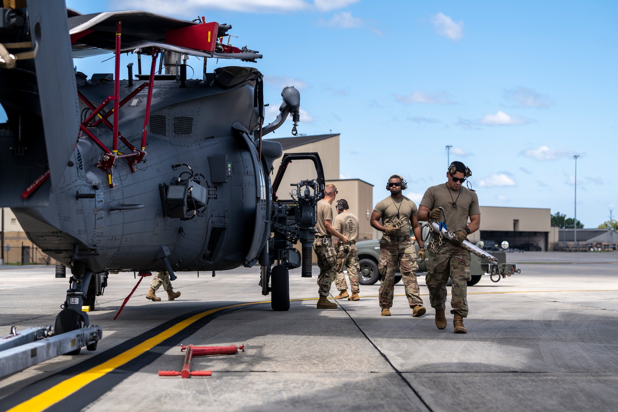 Airmen assigned to the 23rd Wing prepare to load an HH-60W Jolly Green II onto a C-17 Globemaster III