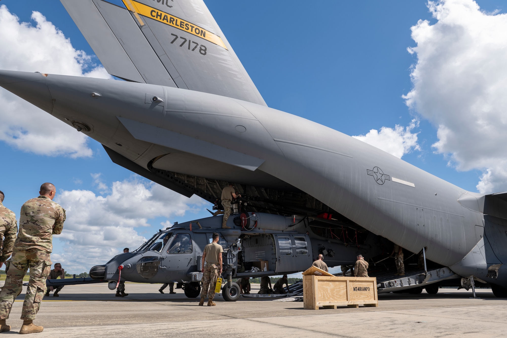 Airmen assigned to the 23rd Wing load an HH-60W Jolly Green II onto a C-17 Globemaster III