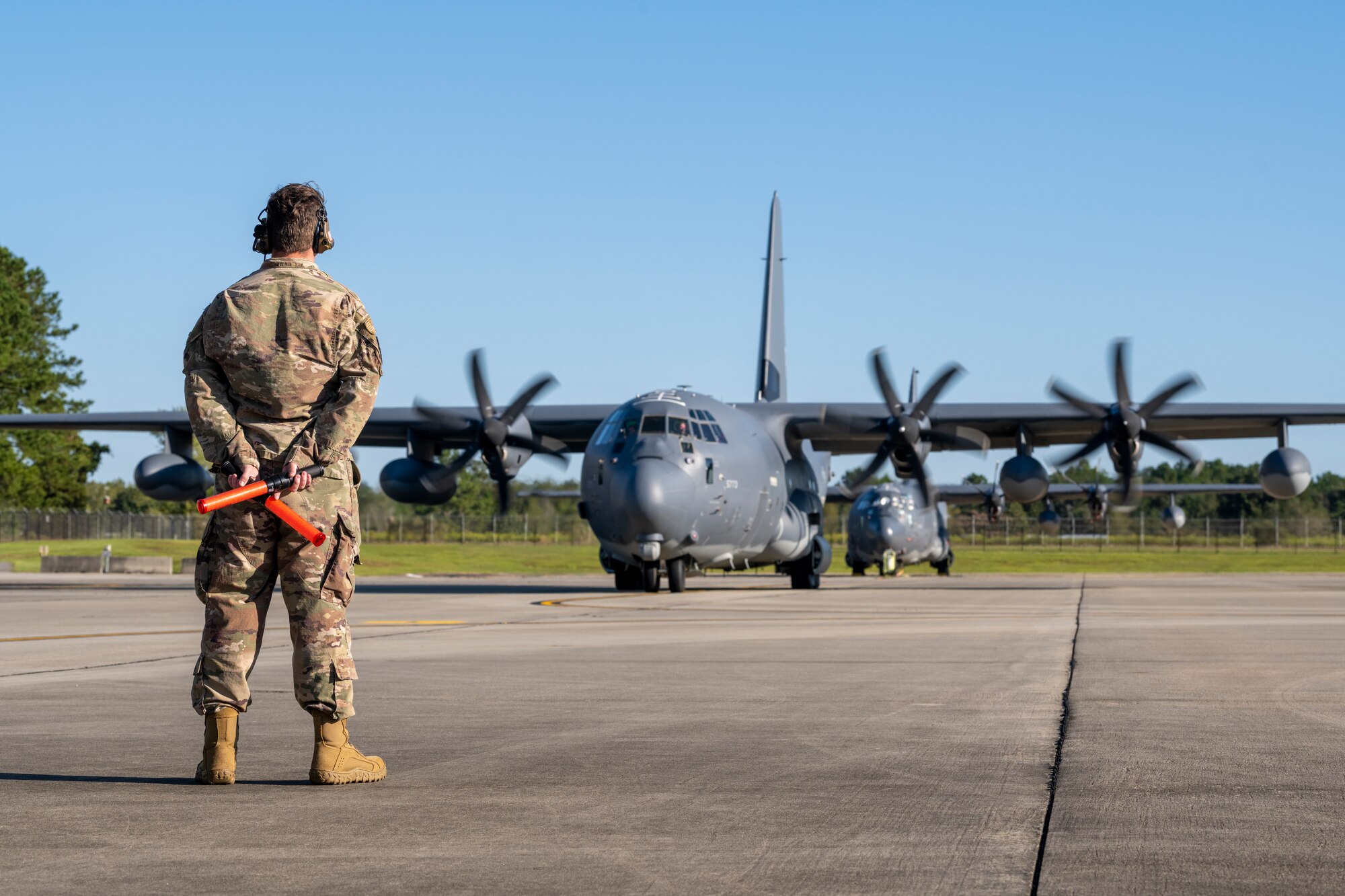 An Airman prepares to marshal an aircraft to the runway.