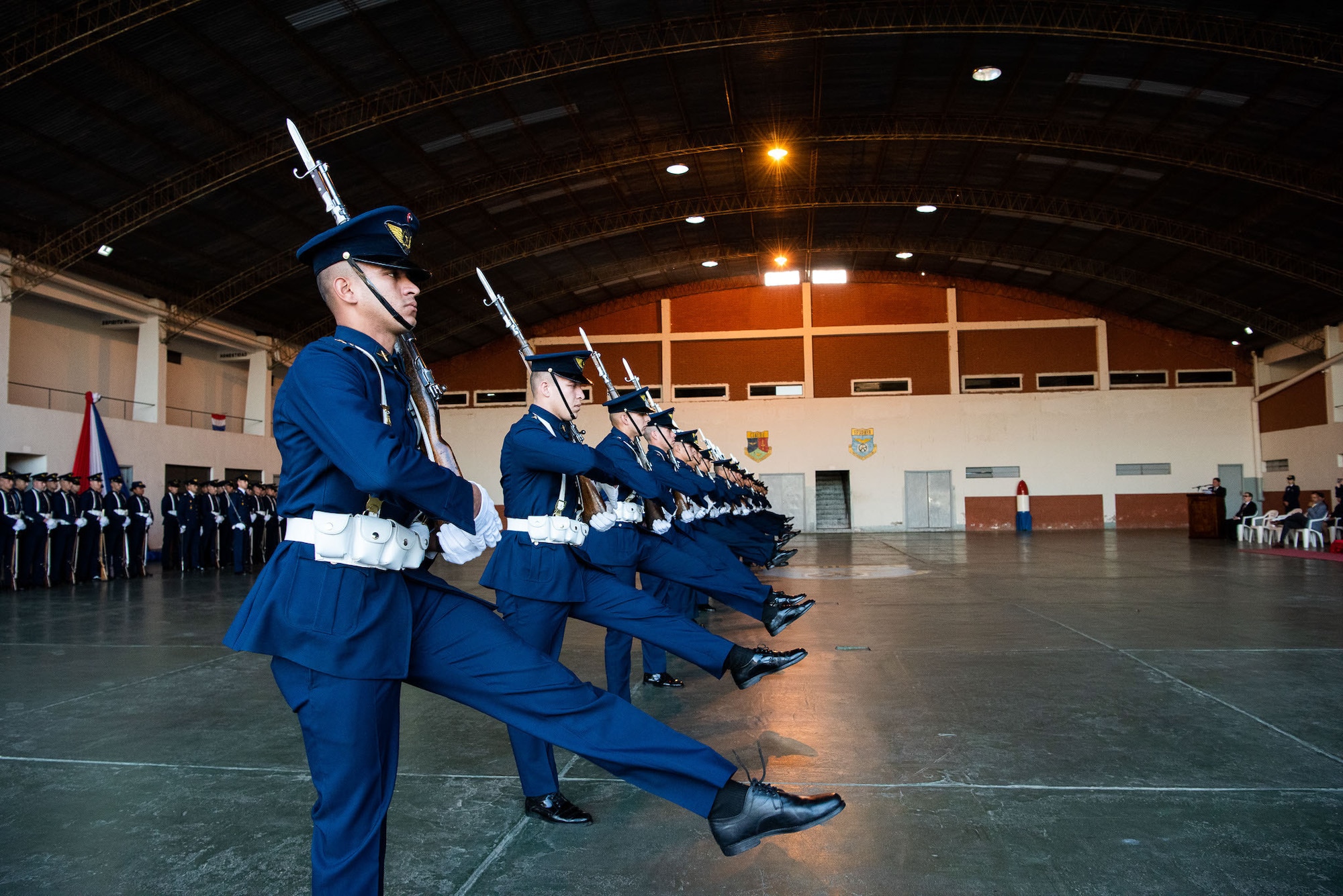 Drill team members kick during a performance