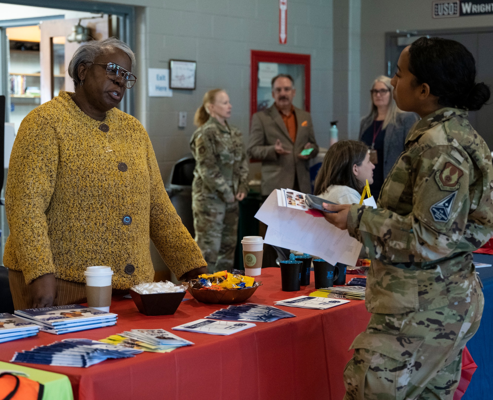 An Airman speaks to a lady at a CFC table.