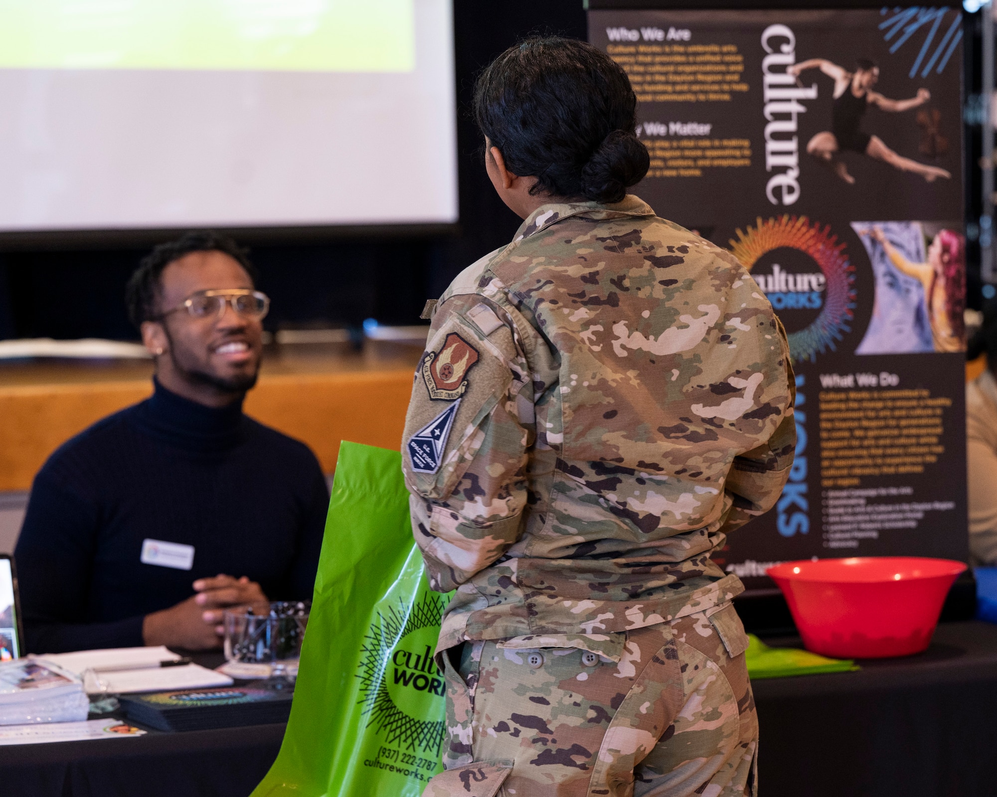 An Airman speaks to a booth attendee.