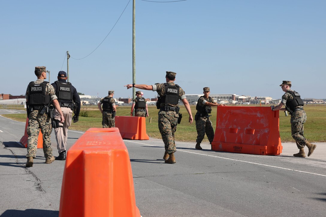 Marine Corps Air Station (MCAS) Cherry Point military police set up barricades for vehicle searches during the Sudden Crisis 2022 training exercise at Marine Corps Air Station Cherry Point, North Carolina, Oct. 11, 2022. The training event exercised command and control, reporting, interoperability with external organizations, and validated tactics, techniques and procedures, in the event the air station needs to elevate its force protection condition.  (U.S. Marine Corps photo by Lance Cpl. Matthew Williams)