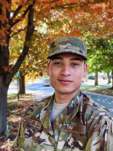 Staff Sgt. Mateo Espinoza in uniform outside. Trees with fall foliage in the background.