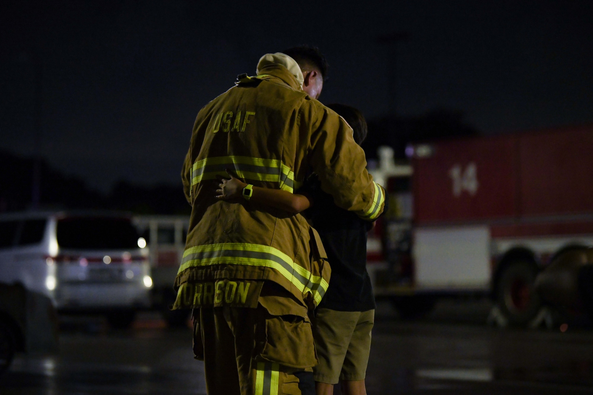 Firefighter hugs his son.