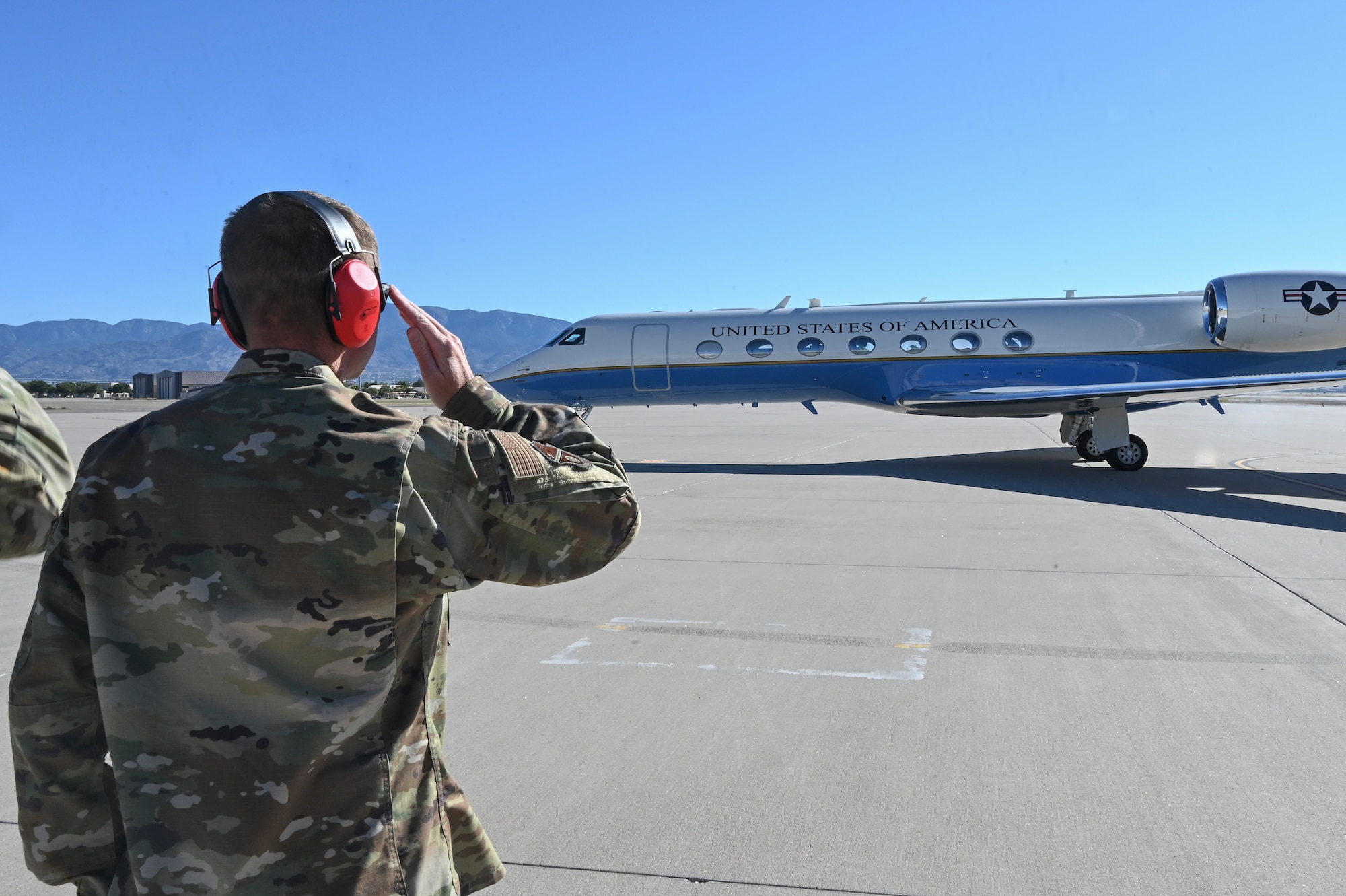 Airman salutes a plane.