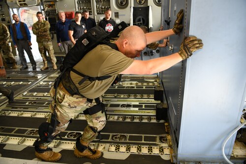 Chief Master Sgt. Sean Storms, aerial port manager with the Air Force Reserve Command’s 445th Airlift Wing, Wright-Patterson Air Force Base, Ohio pushes oversized cargo across the floor of a C-17 Oct. 6, 2022, during an Air Force Research Laboratory demonstration of a pneumatically-powered exoskeleton system developed by ROAM Robotics.