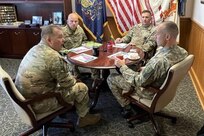 Command Sgt. Maj. Jon Worley, far left, talks with Command Sgt. Maj. Darius Masiulis, far right, Lithuanian Land Forces command sergeant major, at the Pennsylvania National Guard Joint Force Headquarters at Fort Indiantown Gap, Pa., on Oct. 9, 2022. Behind them are Command Sgt. Maj. Andrew Campbell, Pennsylvania Army National Guard command sergeant major, and Sgt. 1st Class John Nebzydoski, State Partnership Program Coordinator–Army. Masiulis, along with Brig. Gen. Arturas Radvilas, Lithuanian Land Forces commander, and Brig. Gen. Modestas Petrauskas, Lithuanian defense attaché to the United States and Canada, visited Fort Indiantown Gap and attended the 28th Infantry Division departure ceremony in Harrisburg on Oct. 9.
