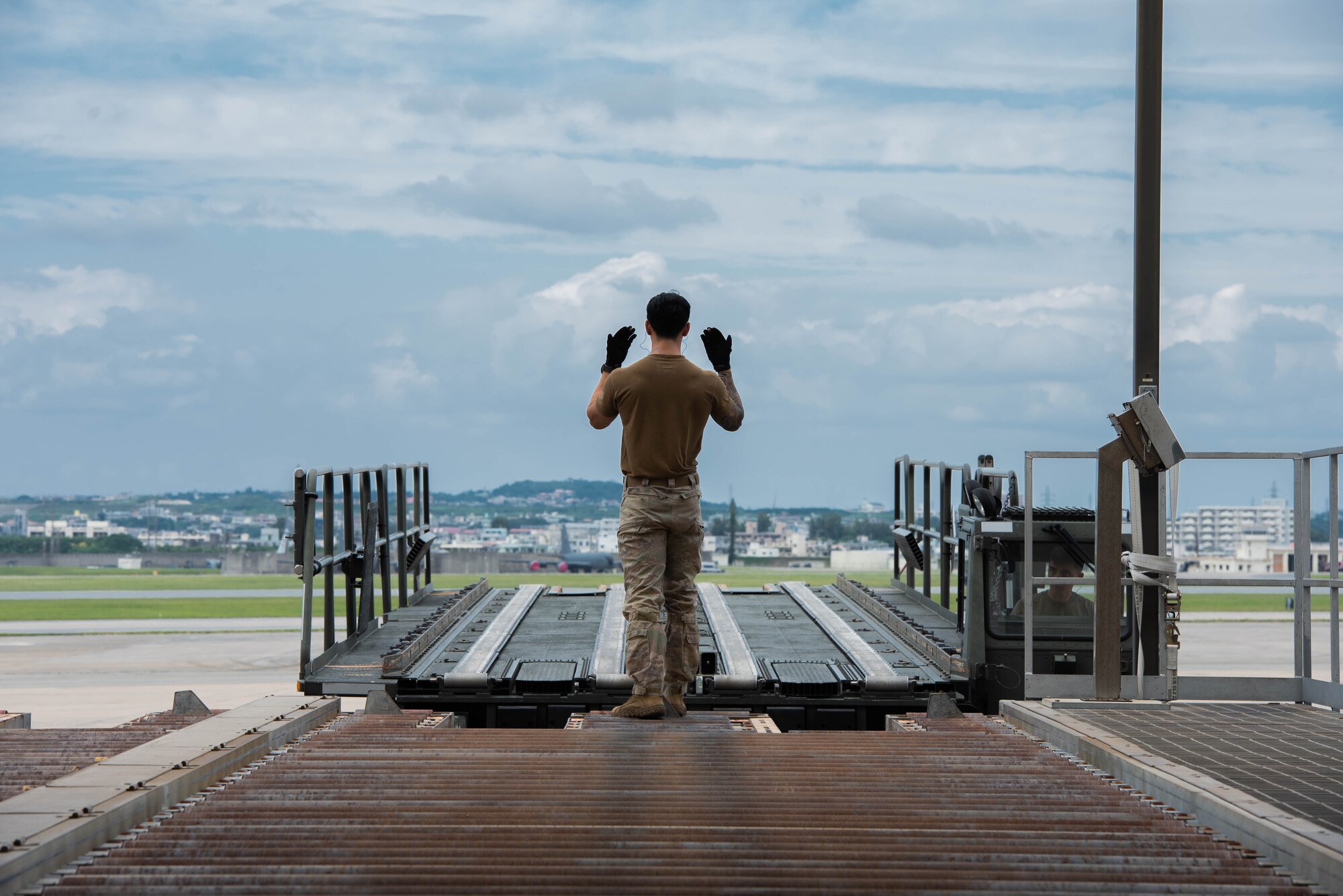 An Airman directs a cargo vehicle to the loading bay.