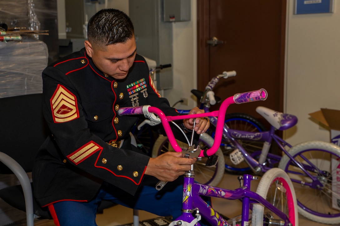 U.S. Marine Corps Gunnery Sgt. Rubin Tan, the Marine Corps Base Camp Blaz Communication Strategy and Operations chief, assembles a donated bike at a storage facility on Andersen Air Force Base, Guam, Dec. 14, 2021. The mission of the Toys for Tots program is to collect new, unwrapped toys and distribute those toys to less fortunate children during Christmas. MCB Camp Blaz participated in the annual campaign to help bring the joy of Christmas and send a message of hope to less fortunate children in Guam and the Commonwealth of the Northern Mariana Islands.