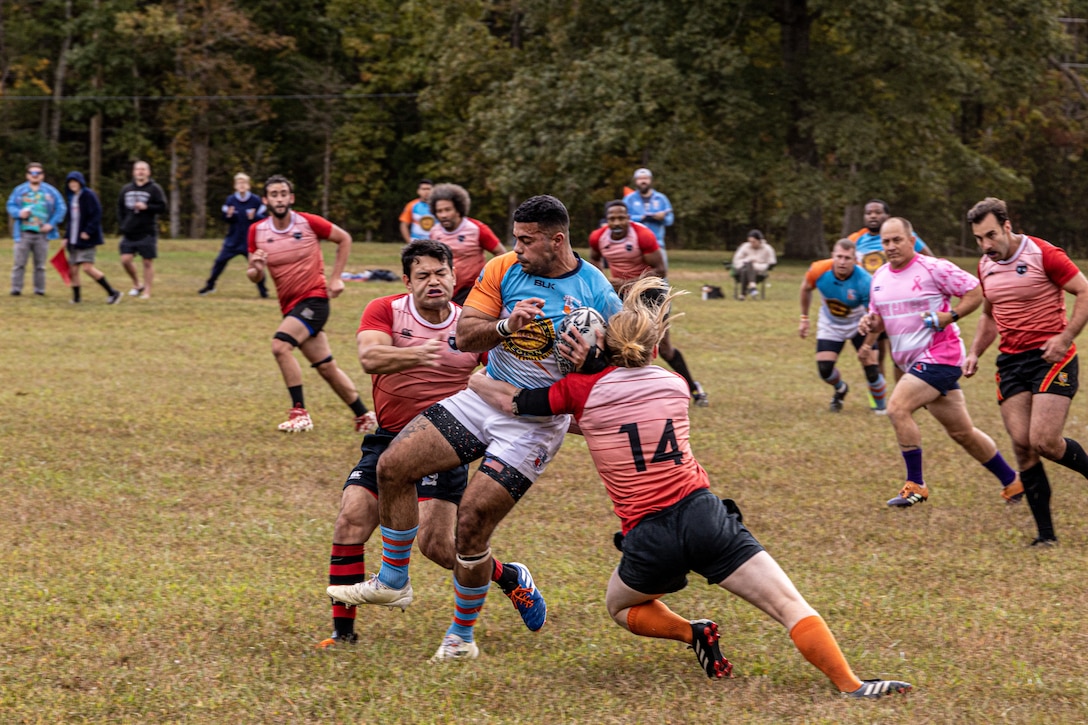 U.S. Marine Corps Corporal Ricardo Gonzalez Jr, an administrative specialist with Marine Corps Recruiting Command, collides with rugby players at Prince William County Rugby Football Club, Triangle, Va, on October 12, 2022. Gonzalez plays in the local rugby team and on the All-Marine Team. (U.S. Marines Corps photo by Lance Cpl. Gustavo Romero)