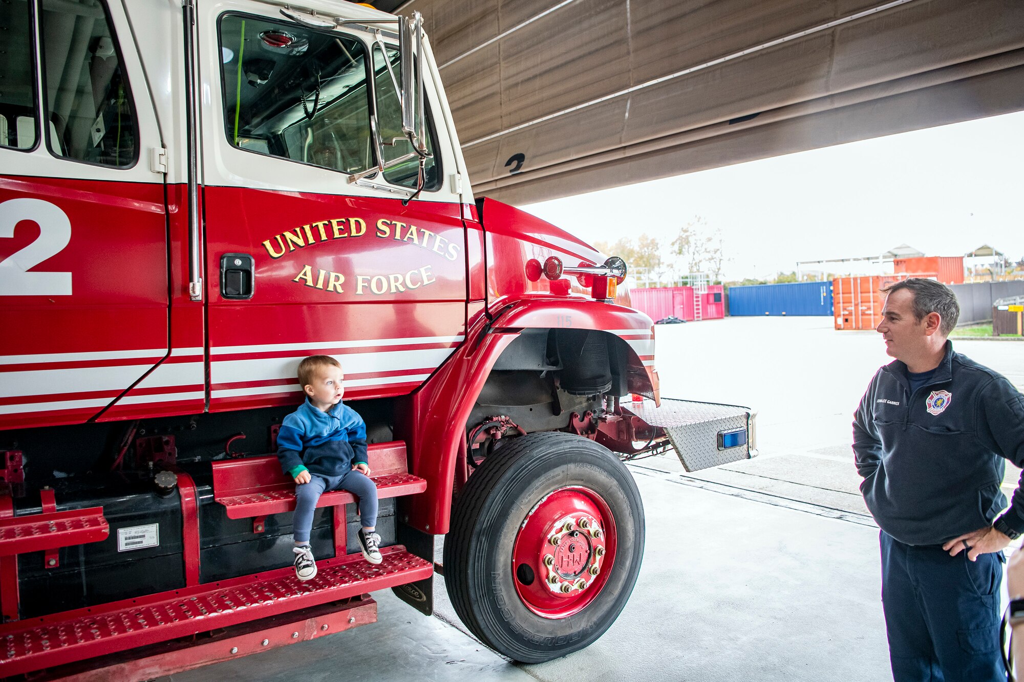 A firefighter from the 423d Civil Engineer Squadron, speaks with a child during an Open house at RAF Alconbury, England, Oct. 14, 2022. The open house was part of Fire Prevention week in which firefighters from the 423d CES educated Airmen and dependents on proper fire safety habits. (U.S. Air Force photo by Staff Sgt. Eugene Oliver)