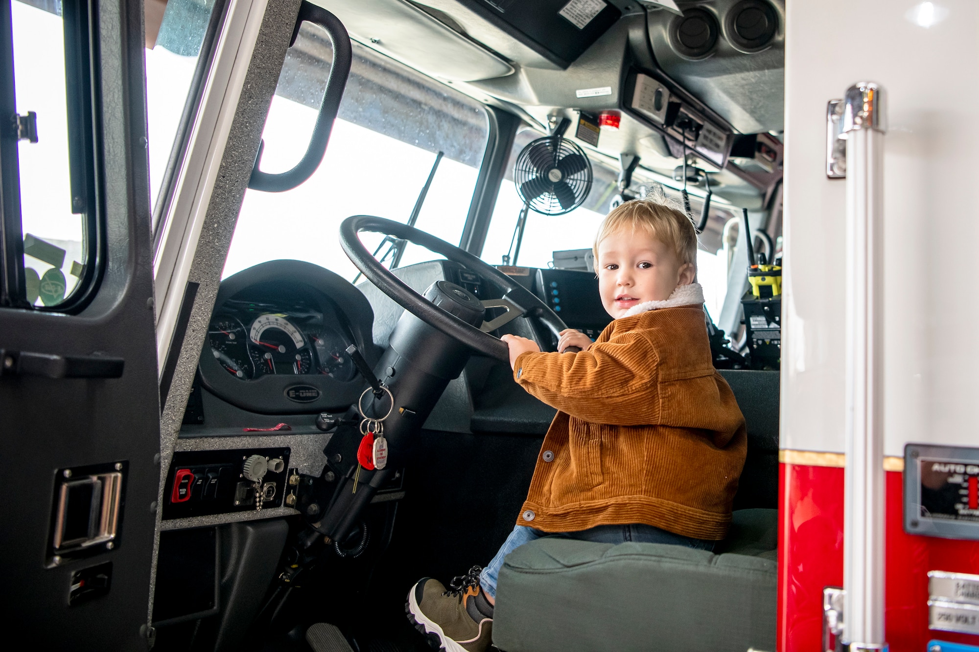 A child holds the steering wheel of a fire truck from the 423d Civil Engineer Squadron, during an Open house at RAF Alconbury, England, Oct. 14, 2022. The open house was part of Fire Prevention week in which firefighters from the 423d CES educated Airmen and dependents on proper fire safety habits. (U.S. Air Force photo by Staff Sgt. Eugene Oliver)