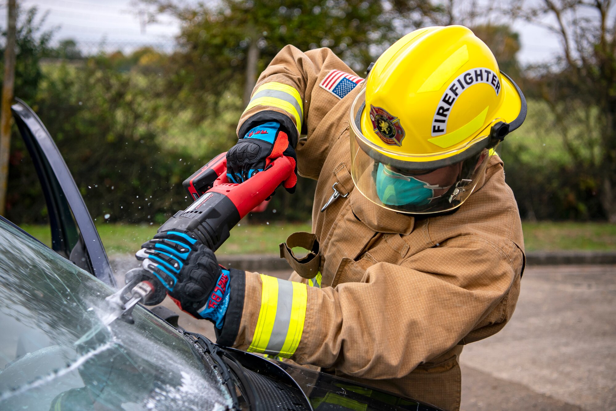 A firefighter from the 423d Civil Engineer Squadron, uses a saw to dismantle a vehicle during a rescue demonstration at RAF Alconbury, England, Oct. 12, 2022. The demonstration was part of Fire Prevention Week in which firefighters from the 423d CES educated Airmen and dependents on proper fire safety habits. (U.S. Air Force photo by Staff Sgt. Eugene Oliver)