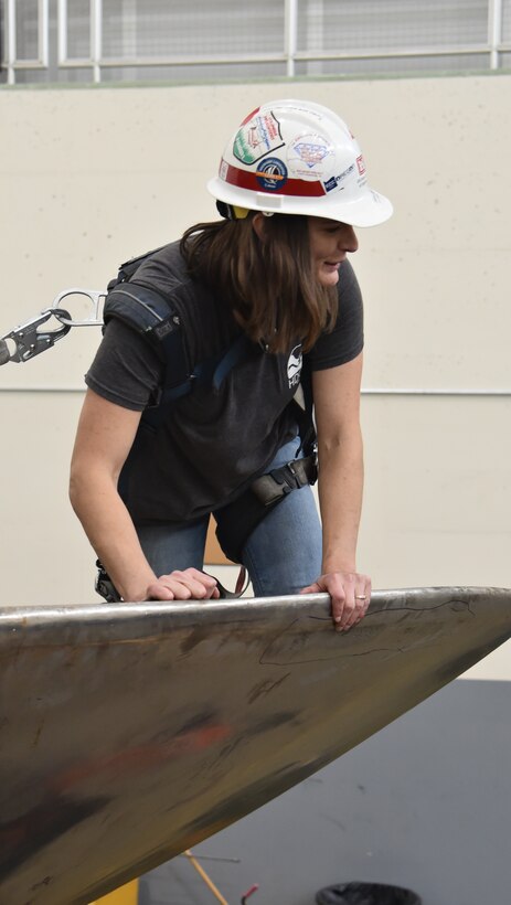 Woman kneeling to inspect equipment