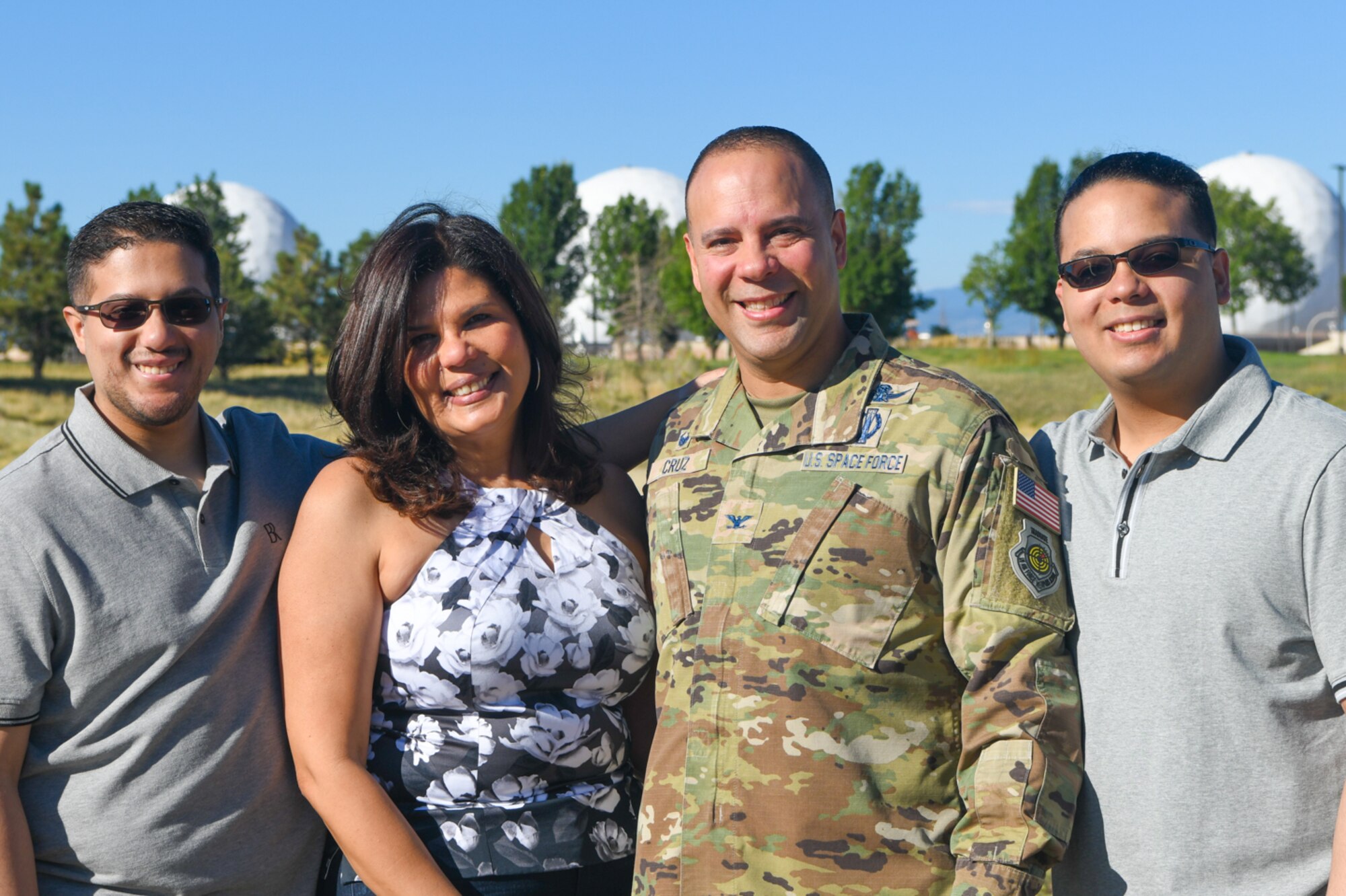 A military member poses with his wife and two sons.