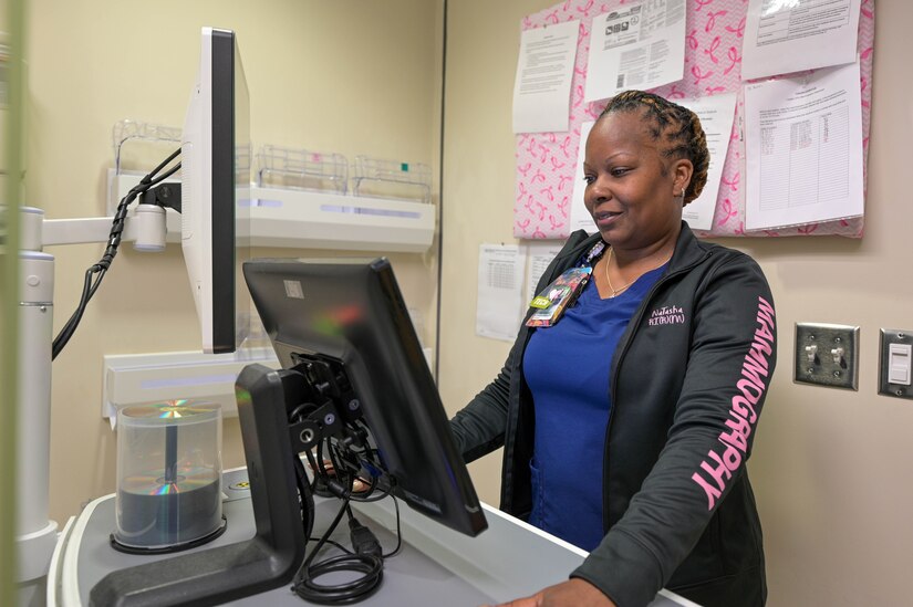 Mammography technician operates computer system.