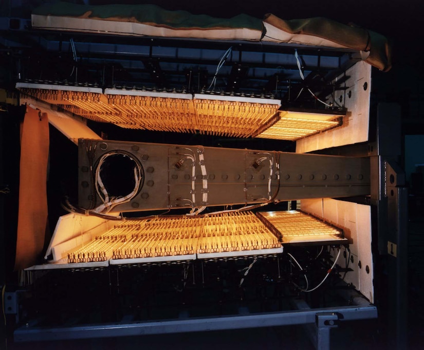 A large piece of equipment sits between two activated heating coils.