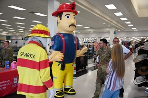 A photo of Airmen talking with fire prevention mascots.