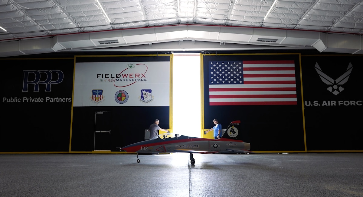 The hangar doors are opened at Hsu STEM Range in Laurel Hill, Florida, July 27, 2022. The unmanned jet took flight with synthetic jet fuel made from captured carbon dioxide. The Air Force’s Project FIERCE demonstrated technology that could allow flightlines and airports to generate their own fuel on-site. (U.S. Air Force photo)
