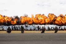U.S. Marines with 3d Littoral Combat Team, 3rd Marine Littoral Regiment, take a knee in front of an explosives display, nicknamed the "Wall of Fire," during a Joint Air-Ground Task Force Demonstration as part of the 2022 Kaneohe Bay Air Show, Marine Corps Air Station Kaneohe Bay, Marine Corps Base Hawaii, Aug. 13, 2022. The air show provided an opportunity to showcase the aircraft, equipment and capabilities of the armed forces to the local community. The Kaneohe Bay Air Show, which contained aerial performances, static displays, demonstrations and vendors, was designed to celebrate MCBH’s longstanding relationship with the local community. (U.S. Marine Corps photo by Cpl. Brandon Aultman)