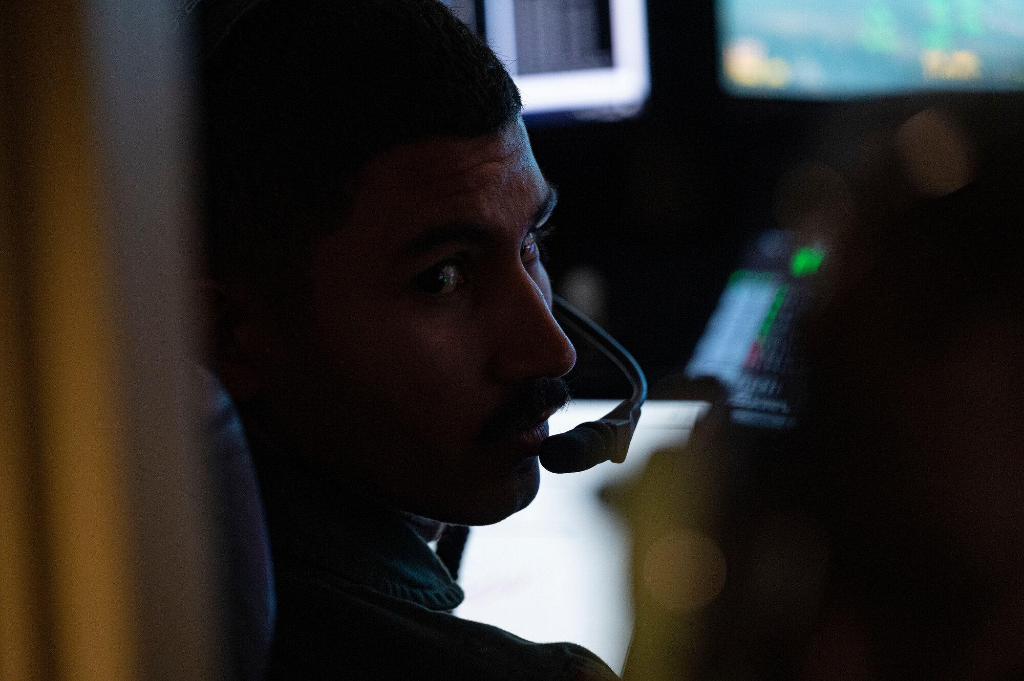 U.S. Air Force 2nd Lt. Cristino Garcia, 6th Attack Squadron MQ-9 Reaper student pilot communicates with an instructor pilot during a training flight in a ground control station, Holloman Air Force Base, New Mexico, Oct. 13, 2022. Student pilots at the 6th ATKS utilize these training scenarios to practice hands-on learning and demonstrate their skill proficiency when piloting an MQ-9.  (U.S. Air Force photo by Airman 1st Class Isaiah Pedrazzini)