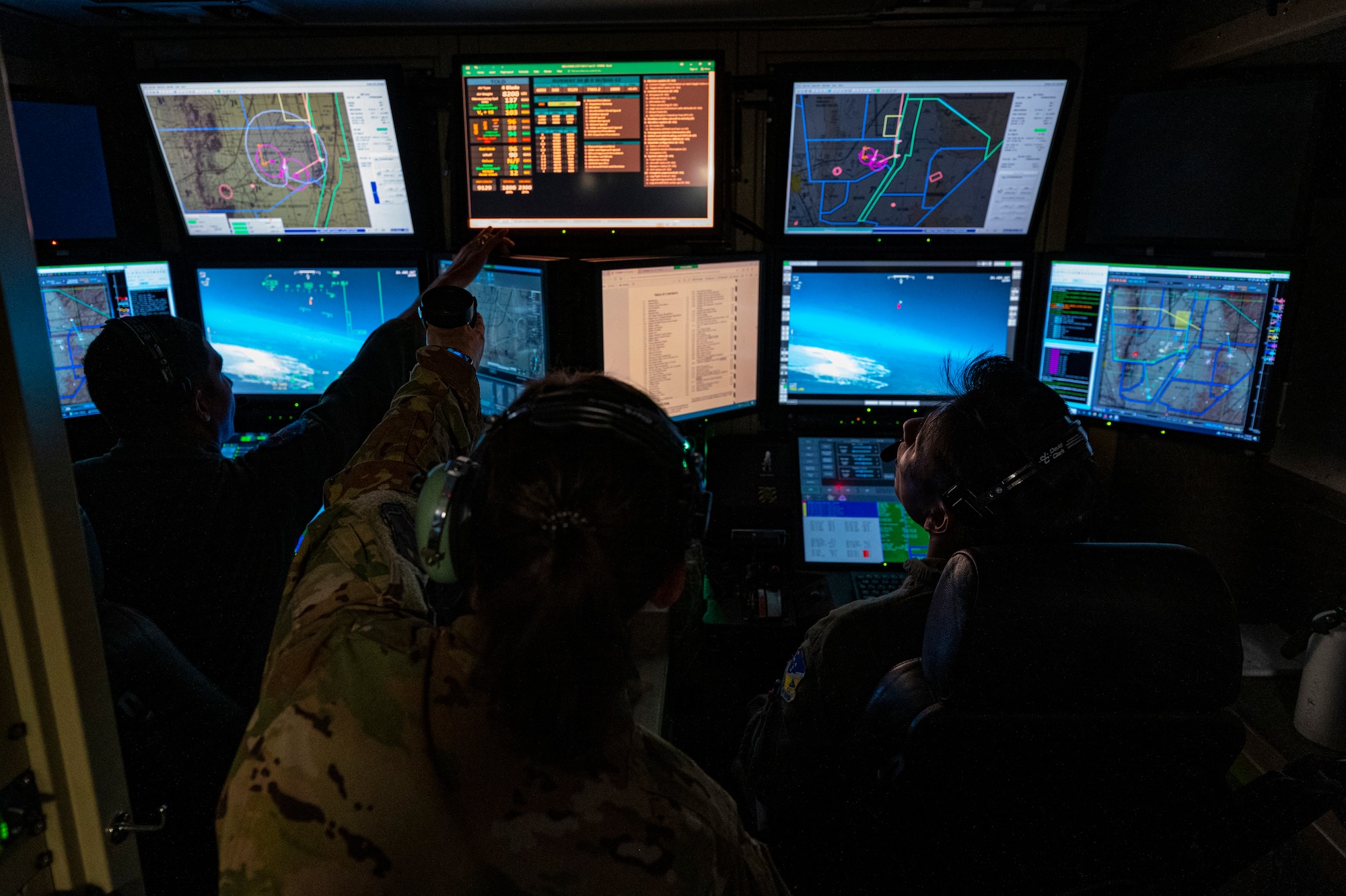 U.S. Air Force Maj. Ashley Meyer, 6th Attack Squadron MQ-9 Reaper instructor pilot, assists U.S. Air Force 2nd Lt. Cristino Garcia, MQ-9 Reaper student pilot, and U.S. Air Force Airman Tenzin Dongak, MQ-9 Reaper student sensor operator, during a training flight in a ground control station, Holloman Air Force Base, New Mexico, Oct. 13, 2022. The 6th ATKS trains both pilots and sensor operators to maintain peak efficiency when operating an MQ-9. (U.S. Air Force photo by Airman 1st Class Isaiah Pedrazzini)