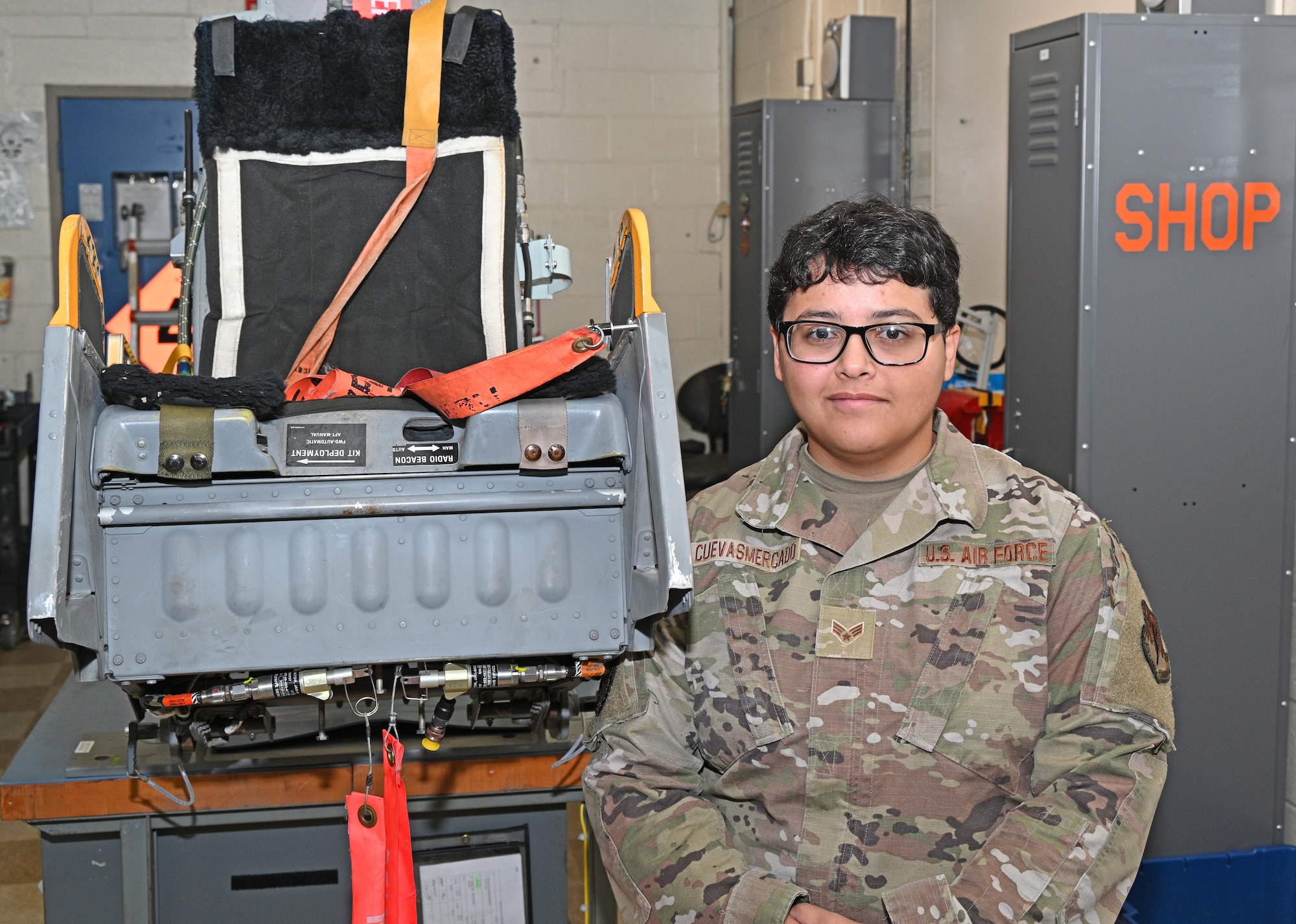 U.S. Air Force Senior Airman Natalia Cuevas Mercado, an egress systems technician with the 175th Maintenance Squadron, poses for a photograph in front of an Advanced Concept Ejection Seat at Warfield Air National Guard Base at Martin State Airport in Middle River, Maryland, October 6, 2022.