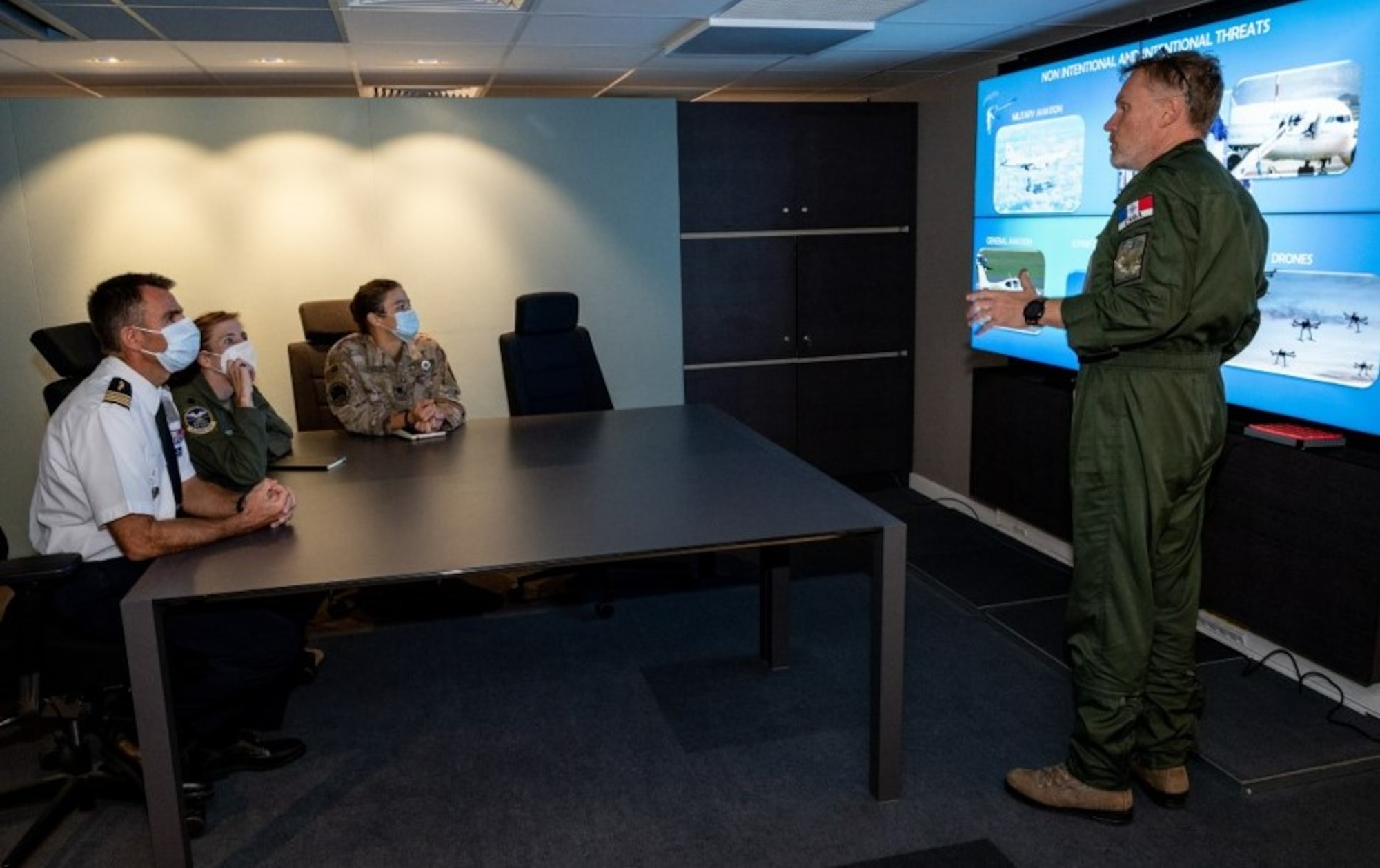 photo of French military officer briefing a group of military personnel sitting at a table