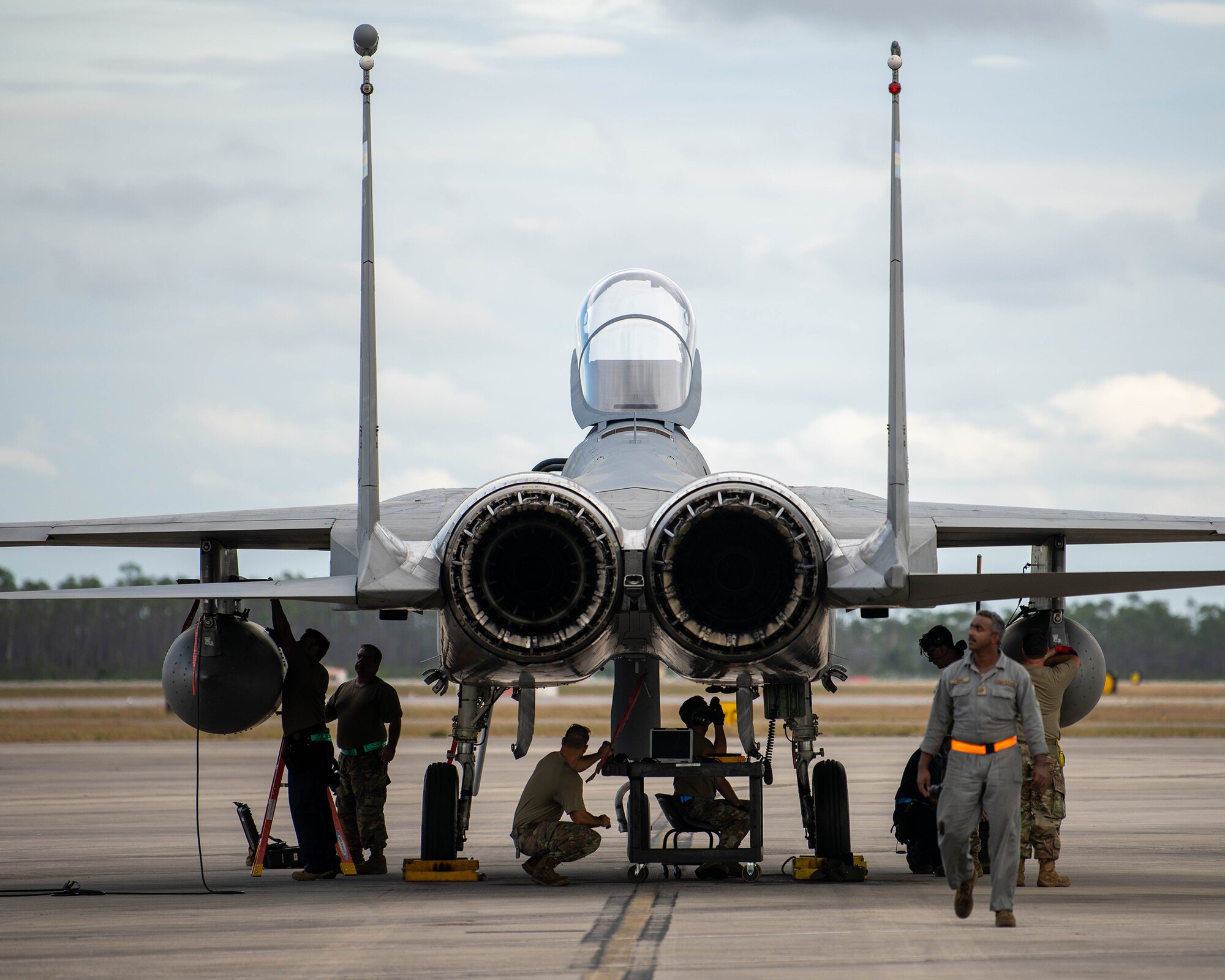 Military members work on a parked jet.