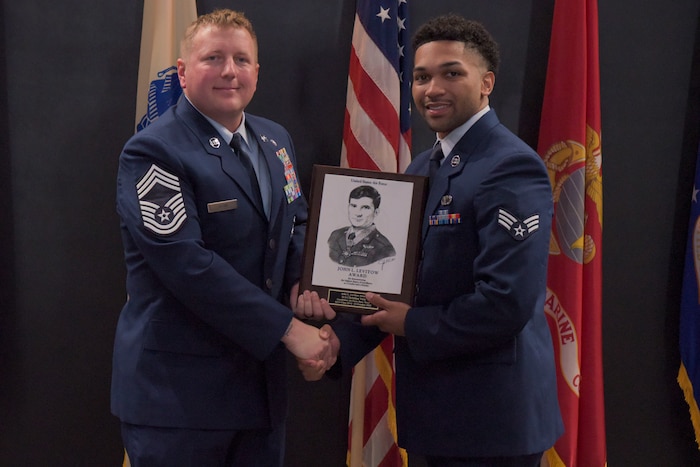 U.S. Air Force Chief Master Sgt. Timothy Ogan, 47th Security Forces Squadron senior enlisted leader, awards Senior Airman Christian Vera, 17th Comptroller Squadron finance technician, with the John L. Levitow award during the Airman Leadership School graduation at the Powell Event Center, Goodfellow Air Force Base, Texas, Oct. 14, 2022. The John L. Levitow award recognizes one student and is based upon all performance tasks, peer stratifications, and the capstone exercise. (U.S. Air Force photo Senior Airman Michael Bowman) An